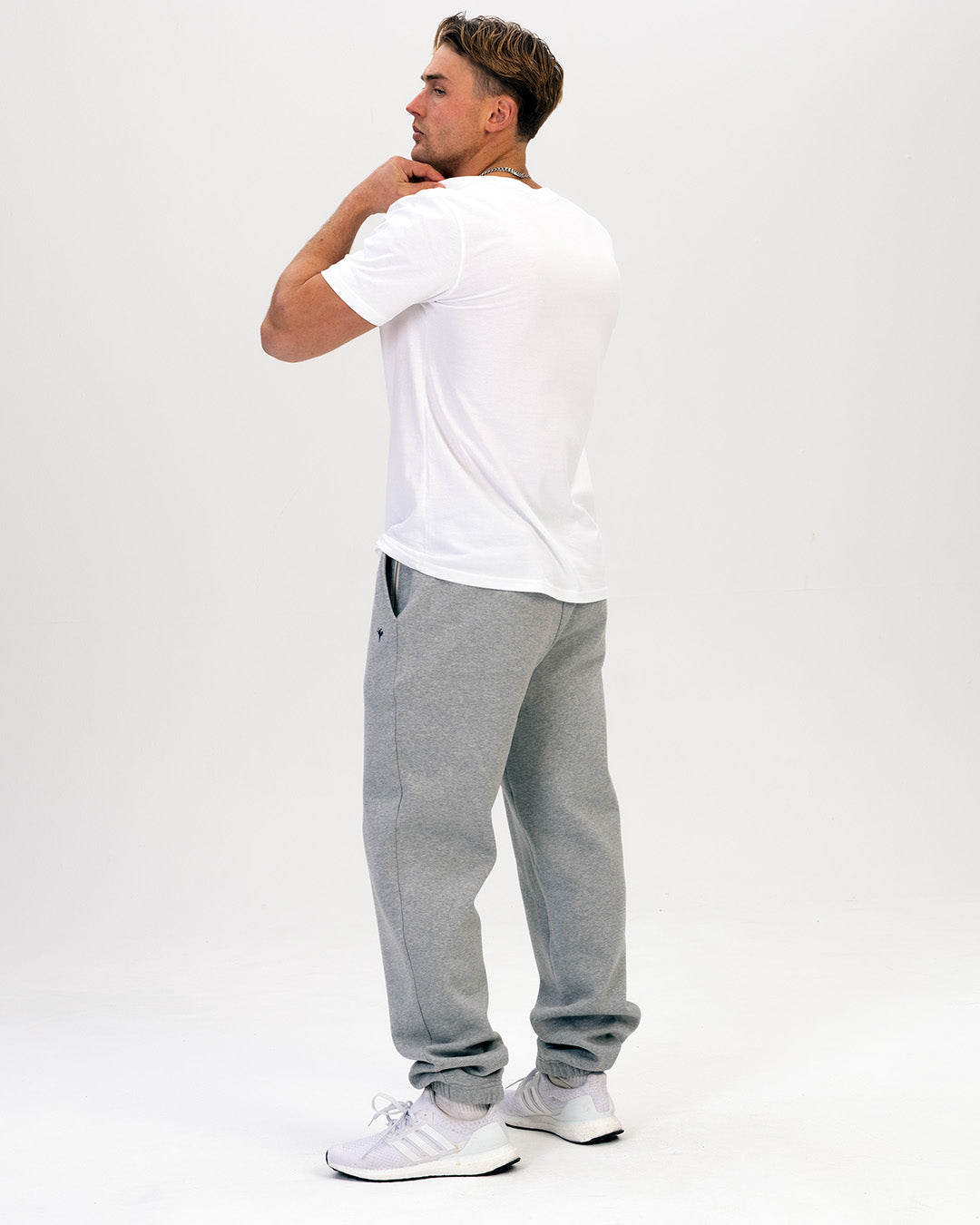 Person wearing a white t-shirt and grey sweatpants