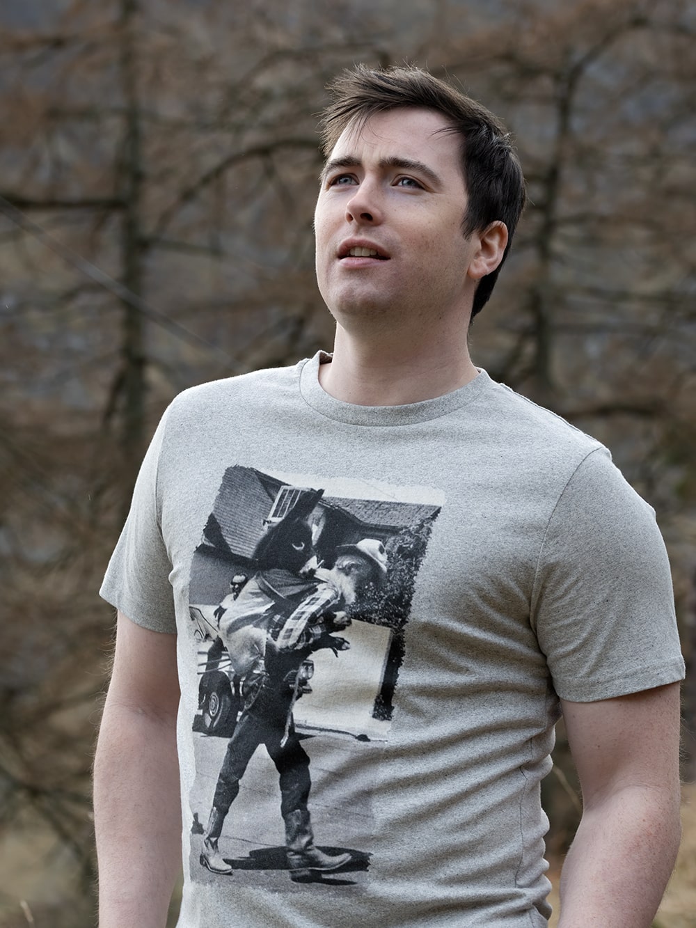 Man wearing a grey t-shirt with a vintage donkey photograph outdoors.